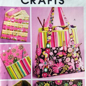 May include: A sewing pattern for a colorful tote bag with floral and striped fabric. The pattern is called McCall's Crafts M5722 Size OSZ.