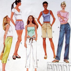 May include: McCall's sewing pattern 3132 for low-rise pants in three lengths or shorts in two lengths. The envelope features illustrations of five figures wearing various styles of pants and shorts in white, yellow, purple, tan, and blue denim.