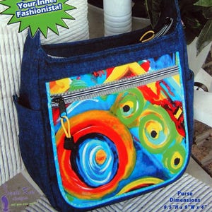 May include: A denim shoulder bag with a colourful abstract design on the front. The bag has a zip closure and side pockets. The purse dimensions are 24cm H x 23cm W x 10cm. The text "The Baggalista" is at the top.
