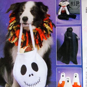 May include: McCall's Crafts M6179 sewing pattern envelope featuring a dog wearing a black, orange, and gold ruffled collar while holding a white skull-shaped treat bag. The envelope displays images of a vampire doll, a ghost figure, and three ghosts.