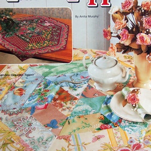 May include: A book titled "Reversible Table Toppers" by Anita Murphy. The cover features a red and green title with a floral patterned table topper and a close-up of a second table topper with a patchwork design.