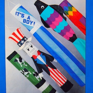 May include: A book cover for "Let's Make Windsocks" displaying various windsock designs, including a fish, Uncle Sam, and other creative patterns. The text "IT'S A BOY!" is printed on one of the windsocks.