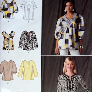 May include: A Simplicity 2696 sewing pattern envelope for tops in sizes R5 14, 16, 18, 20, 22. The cover displays six variations of blouses with different necklines, sleeve lengths, and patterns, including yellow, gray, and white geometric prints.