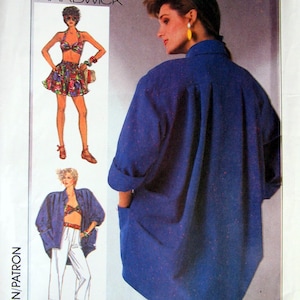 May include: Simplicity sewing pattern featuring a blue oversized shirt with pockets. The pattern includes illustrations of a two-piece outfit and a jacket with white pants. The pattern is designed by Cathy Hardwick.