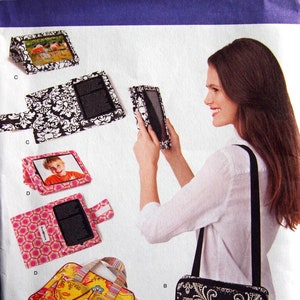 May include: A sewing pattern for a tablet case with different designs. The pattern is called Simplicity 1630 os. The pattern includes instructions for making a black and white paisley design case, a pink and white geometric design case, a yellow and blue floral design case, and a black and white damask design case.