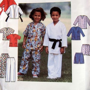 May include: Simplicity sewing pattern featuring children's clothing. The pattern includes a karate uniform with a black belt and a matching outfit with a cartoon dog print. Additional clothing designs are also shown.