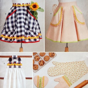 May include: Simplicity sewing pattern S9873 features aprons, oven mitts, and a towel. The aprons are shown in a pink and a black and white checkered design. The oven mitts and towel have a floral pattern. The pattern is designed and printed in the USA.