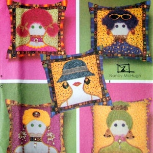 May include: A Simplicity Crafts pattern for making four different decorative cushions. Each cushion features a different doll face with colourful hair, clothing, and accessories. The pattern is titled "4970" and includes instructions for making the cushions.