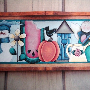 Peut inclure: Une peinture encadrée en bois représentant une scène fantaisiste avec un bonhomme de neige, une pastèque, une citrouille, un nichoir, un ange et un arrosoir. La peinture est réalisée dans des couleurs vives, notamment le bleu, le vert, le rouge et le jaune.