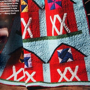 May include: A red, white, and blue quilt with a design of three barns. The quilt is quilted with a wavy pattern and has a green border. The quilt is made with a variety of fabrics and has a rustic feel.