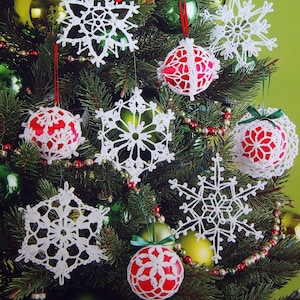 May include: A softcover book titled Big Book of Thread Ornaments featuring over 100 crochet designs. The cover displays a Christmas tree decorated with white crocheted snowflake ornaments and red spherical ornaments wrapped in white crochet lace.