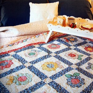 May include: A white bed with a blue and white floral quilt. The bed has a white headboard with a canopy and two pillows. A white tray with a teapot, cup, and strawberries is on the bed.