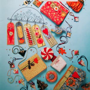 May include: A collection of handmade fabric crafts, including pouches, ornaments, and decorative items, arranged on a light blue surface. The image features the text "Sew Necessary" and "Art to Heart". Various colors and patterns are visible.