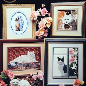 May include: Cross stitch pattern featuring four different images of cats. The first image shows a Siamese cat sitting on a rug. The second image shows a white cat with a long tail sitting on a rug. The third image shows a group of cats with different coloured fur. The fourth image shows a black and white cat looking out a window. The title of the pattern is "Fabulous Felines".