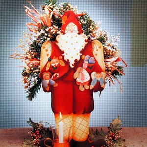 May include: A festive wooden Santa Claus figure with a red coat, holding small toy figures. The figure is decorated with a white beard and a red hat. The words "Finders Keepers" and "A Yuletide Edition" are at the top. A lit candle and matches are at the base.