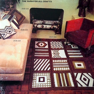 May include: A crochet rug with a variety of patterns in brown, white, and beige. The rug is made up of nine squares, each with a different design. The rug is on a wooden floor in front of a fireplace.