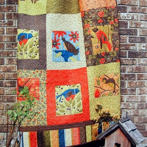 May include: A colorful quilt with a patchwork design featuring birds, flowers, and leaves. The quilt is titled "Cheeper by the Dozen" and the page number is 25.