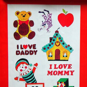 May include: A sheet of iron-on transfer stickers featuring a teddy bear, a clown, a house, a heart, and blocks that spell out "I love Daddy" and "I love Mommy".