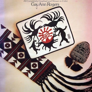 Puede incluir: Una portada de libro con el título "Tribal Designs for Needlepoint" y el autor "Gay Ann Rogers". La portada presenta un fondo blanco con diseños de punto de aguja negros y rojos.