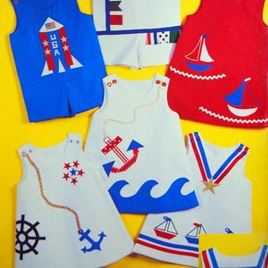 Puede incluir: Una colección de conjuntos sin mangas para niños en rojo, blanco y azul. Los diseños incluyen un cohete con texto USA, veleros, anclas y banderas náuticas. Los conjuntos tienen cierres de botón en los hombros.