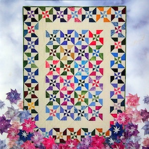 Puede incluir: Una portada de libro con el título "Double Pinwheel Quilt" en texto verde sobre fondo blanco. La portada del libro presenta una colcha colorida con un patrón de molinete. El libro se titula "Quilt in a Day" y la autora es Eleanor Burns.