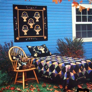 Peut inclure: Une courtepointe noire et blanche avec un motif en losange est présentée sur un lit avec un ours en peluche assis sur une chaise en bois. La courtepointe est faite de divers tissus, dont du noir, du blanc et du violet. La courtepointe est décorée de petites fleurs brodées. La courtepointe est intitulée "Heart O' Gold".