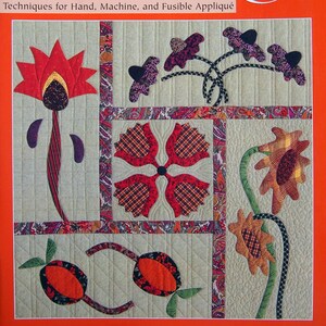 Puede incluir: Portada de libro con el título "The Easy Art of Appliqué" de Mimi Dietrich y Roxi Eppler. La portada presenta una colcha colorida con varios diseños florales en rojo, naranja, marrón y morado.