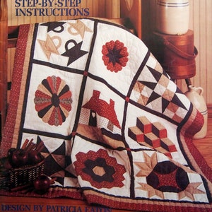 Peut inclure: Un livre intitulé "Apprenez à faire des quilts" avec un guide d'instructions étape par étape. La couverture présente une courtepointe avec une variété de motifs de patchwork colorés.