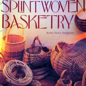 May include: A book cover titled SPLINT WOVEN BASKETRY by Robin Taylor Daugherty. The cover features various woven baskets in shades of brown and tan, including round baskets with handles and coils of weaving material arranged in a collection.