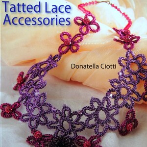 May include: A book cover titled Tatted Lace Accessories by Donatella Ciotti, published by Search Press. The cover features a purple and pink tatted lace necklace with floral motifs and a dark beaded pendant, set against a soft peach fabric.