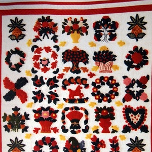 Peut inclure: Une courtepointe miniature d'album en point de piqûre blanche avec une bordure rouge. La courtepointe présente une variété de motifs colorés, notamment des fleurs, des arbres, des cœurs et des ananas. Le texte "Punch Needle Miniature Album Quilt" est imprimé en bas de la courtepointe.