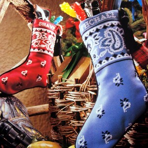 May include: Two Christmas stockings, one red with white trim and the name "Shave" embroidered on it, and one blue with white trim and the name "Michael" embroidered on it. Both stockings are filled with gifts and candy canes.