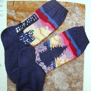 Puede incluir: Dos calcetines de punto coloridos con una base azul y un patrón multicolor de rosa, amarillo y rojo. Los calcetines están sobre una superficie marrón texturizada.