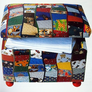 Può includere: Un pouf di stoffa patchwork colorato con una fodera in tessuto bianco. Il pouf ha una base in legno rosso con piedini in legno rosso.