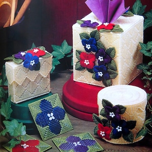 Peut inclure: Ensemble de boîtes à mouchoirs faites à la main, une petite boîte et des dessous de verre. Les articles sont en canevas de plastique crème et décorés de fleurs brodées colorées en rouge, bleu et violet. La boîte à mouchoirs a un éventail de papier violet.