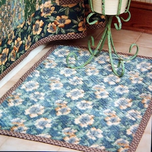 May include: A blue and white patterned bath mat with a brown border. The mat is made of a soft, plush material and is perfect for adding a touch of style to any bathroom.