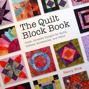 May include: The cover of "The Quilt Block Book" features a variety of colorful quilt block designs. The book's title is prominently displayed, along with the author's name, Nancy Wick. The book promises fresh and versatile designs for quilts, clothes, accessories, and decor.