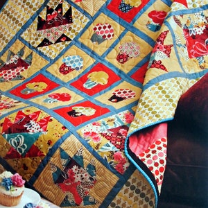 May include: A colorful quilt with a patchwork design featuring various patterns and colors, including red, yellow, blue, and green. The quilt is made of fabric squares sewn together to create a unique and intricate design. The quilt is folded and draped over a brown couch.
