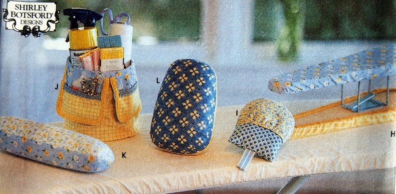 May include: A collection of sewing and ironing accessories, including a yellow and blue organizer, a blue ironing board cover, a blue and yellow iron rest, and a blue and yellow padded sleeve board. The accessories are decorated with floral and geometric patterns.
