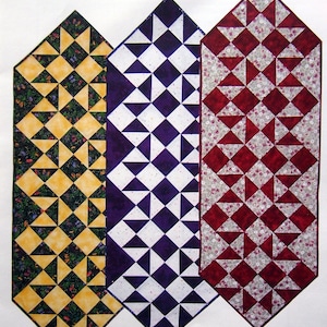 May include: Image of a quilt pattern titled "Hannah's Stacked Stars." The design features three vertical panels with star patterns in yellow and green, purple and white, and red and white. The Lehmann Quilting logo is at the bottom.