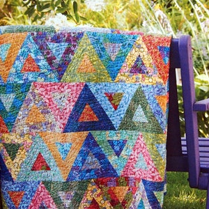 Op de afbeelding: Een doorgestikte deken met een herhalend geometrisch patroon van driehoeken in diverse levendige kleuren, waaronder rood, blauw, geel, groen en roze. De stoffen vertonen uiteenlopende bloemen- en abstracte prints, allemaal verbonden met zichtbare stiksels.