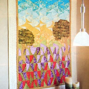 May include: A colorful quilt with a patchwork design featuring a sky, trees, and a field of flowers. The quilt is made of various fabrics in shades of blue, green, yellow, red, and purple.