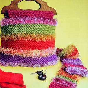May include: A colorful knitted bag with a wooden handle, a matching scarf, and a pair of red knitted mittens. The bag and scarf are striped with pink, green, orange, and purple yarn. The yarn has a fuzzy texture.