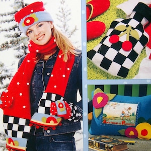 Peut inclure: Un ensemble écharpe, bonnet et mitaines rouges à pois blancs, avec des carreaux noirs et blancs et des motifs floraux. L'ensemble est présenté avec une veste en jean. D'autres articles incluent un coussin en forme de bouteille à carreaux noirs et blancs avec des cerises et un coussin bleu avec le texte "Anything is Possible."