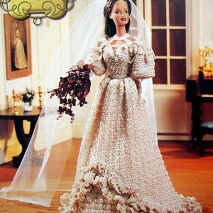 May include: A doll wearing a crocheted wedding dress, veil, and holding a bouquet of dark red flowers. The dress is light beige with a ruffled hem. The doll is part of "The Southern Belle Collection" and is labelled "Wedding Day".