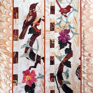 May include: A quilt featuring a side border design with a Nightingale, Song Finch, Hibiscus Tree, and Gourd Vine. The quilt showcases detailed applique work with birds, flowers, and vines in shades of red, pink, and green against a white background.