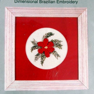 May include: A craft kit for a poinsettia embroidery project. The kit includes a 7x7 inch printed cream poly/cotton fabric, rayon threads, needles, and instructions. The finished embroidery is shown in a red frame.