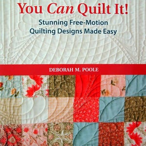 Puede incluir: La portada del libro "You Can Quilt It!" presenta un fondo acolchado blanco con una pancarta roja. El título está en rojo, con el subtítulo "Stunning Free-Motion Quilting Designs Made Easy". El nombre del autor, Deborah M. Poole, también está visible.