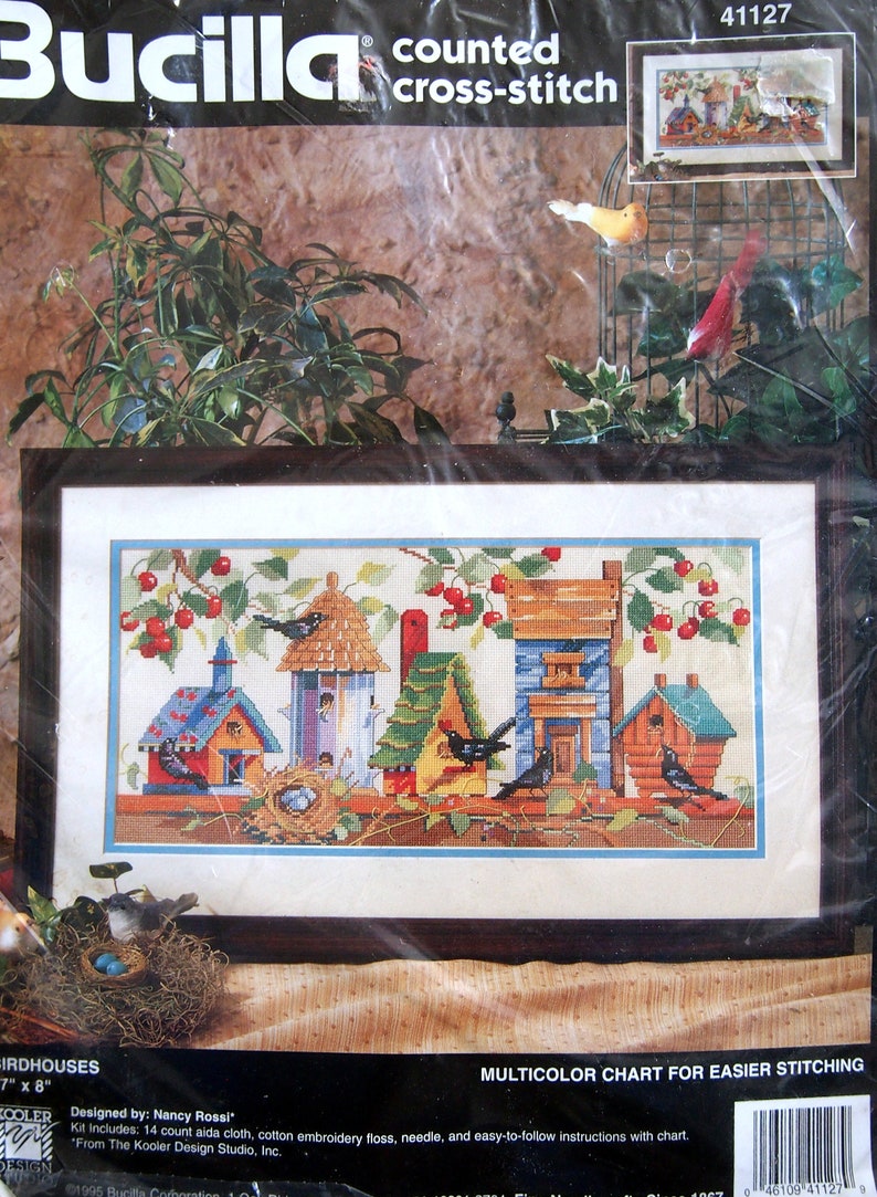 May include: Bucilla counted cross-stitch kit, 41127, titled "Birdhouses". The kit includes 14 count aida cloth, cotton embroidery floss, needle, and easy-to-follow instructions with chart. The image shows a colorful cross-stitch design of birdhouses with birds and cherries.