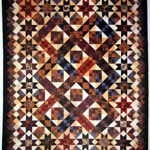 May include: A patchwork quilt with a geometric design. The quilt features squares, diamonds, and star shapes in shades of brown, red, blue, and cream. The border is a dark brown, and the overall design is symmetrical.